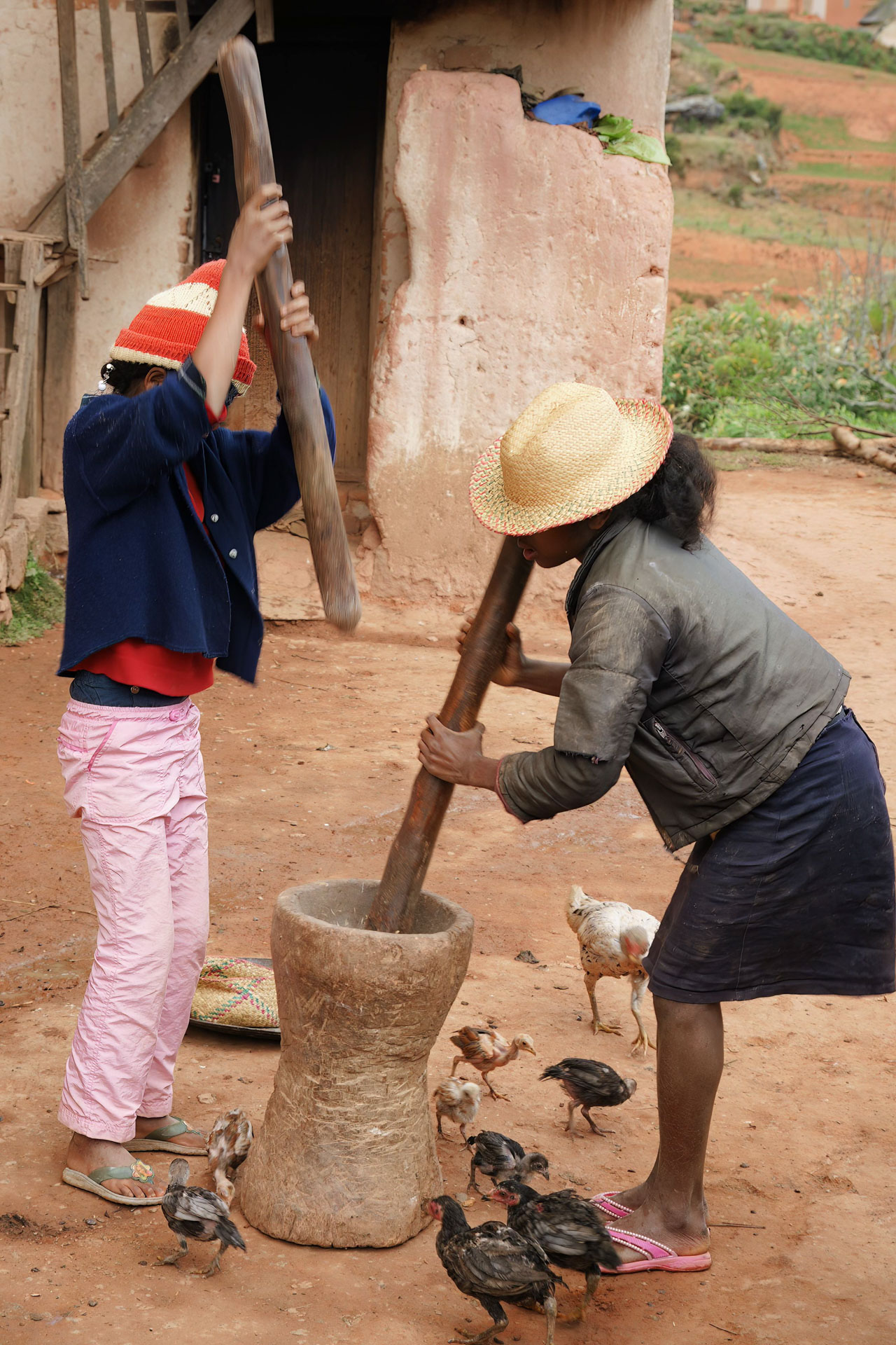 Kinder zeigen, wie sie durch Stampfen Mehl herstellen